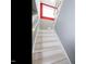 Stairway with crisp white treads and metal railings leading to a room with a red accent wall and window at 314 Montelena Pl, Cary, NC 27513