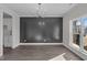 Dining room featuring modern lighting, wood accent wall, hardwood floors, and natural light at 316 Little Lady Trail, Zebulon, NC 27597