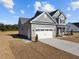 Two-story home featuring attached garage, paved driveway, and landscaping at 316 Little Lady Trail, Zebulon, NC 27597