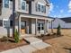 Charming front porch with decorative columns, wooden door, and landscaped yard at 316 Little Lady Trail, Zebulon, NC 27597