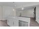 Kitchen island with white cabinets, quartz countertop, stainless steel dishwasher, and pendant lighting at 316 Little Lady Trail, Zebulon, NC 27597