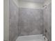 Close-up of shower featuring hexagon tile, white tub, and brushed nickel hardware at 316 Little Lady Trail, Zebulon, NC 27597