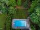 Aerial view of a rectangular swimming pool surrounded by green grass, landscaping and a privacy fence at 3421 Griffice Mill Rd, Raleigh, NC 27610