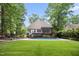 Serene backyard oasis featuring a private pool, lush lawn, mature trees and screened in porch at 3421 Griffice Mill Rd, Raleigh, NC 27610