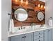 Modern bathroom with dual sinks, rustic wood wall and decorative mirrors at 3421 Griffice Mill Rd, Raleigh, NC 27610