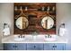 A bathroom features double sinks, a wood accent wall, decorative lighting and mirrors, with stylish fixtures and towel racks at 3421 Griffice Mill Rd, Raleigh, NC 27610