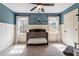 Charming Bedroom with blue walls, white wainscoting, and plenty of natural light from two windows at 3421 Griffice Mill Rd, Raleigh, NC 27610