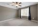 A neutral carpeted bedroom with curtains and a ceiling fan at 3421 Griffice Mill Rd, Raleigh, NC 27610