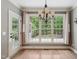 A dining room offers a neutral color palette, large windows with outdoor views, and modern lighting fixtures at 3421 Griffice Mill Rd, Raleigh, NC 27610