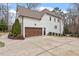 Side exterior view of a home with a two-car garage, manicured landscaping, and a spacious driveway at 3421 Griffice Mill Rd, Raleigh, NC 27610