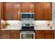 Close up of a modern kitchen featuring stainless steel appliances and dark wood cabinetry at 3421 Griffice Mill Rd, Raleigh, NC 27610