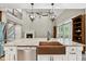 Kitchen island with copper sink and stainless steel dishwasher, open to the living room with a fireplace at 3421 Griffice Mill Rd, Raleigh, NC 27610
