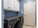 Laundry room with a set of front load washer and dryer and cabinets at 3421 Griffice Mill Rd, Raleigh, NC 27610