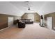 A bonus room with a dark leather couch and a wall-mounted TV at 3421 Griffice Mill Rd, Raleigh, NC 27610