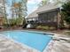 Backyard pool with diving board and house with an elevated deck and screened porch in wooded area at 3421 Griffice Mill Rd, Raleigh, NC 27610