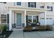 Inviting front porch with seating area, stylish columns, and a lovely blue front door at 3508 Longleaf Estates Dr, Raleigh, NC 27616