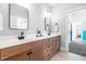 Well-lit bathroom features double sinks, modern mirrors, and an open doorway to the bedroom at 409 Tintern Ln, Apex, NC 27523