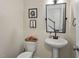 Powder room featuring a pedestal sink, updated hardware and decor at 421 Pine Burr St, Fuquay Varina, NC 27526