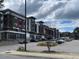 Multi-story building with retail shops and a parking lot on a cloudy day at 4443 Crystal Breeze St, Raleigh, NC 27614