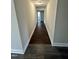 Bright hallway with dark wood-look flooring and neutral paint, leading to well-lit rooms at 4989 Nc 217, Erwin, NC 28339