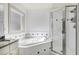 Bright bathroom featuring a soaking tub with window and a glass shower enclosure at 509 Edgemore Ave, Cary, NC 27519