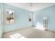 Bedroom with pale-blue walls, plush carpet, ceiling fan, and windows with view to leafy street at 509 Edgemore Ave, Cary, NC 27519