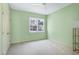 Bedroom featuring pale-green walls, plush carpet, ceiling fan, and window with view to leafy street at 509 Edgemore Ave, Cary, NC 27519