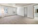 Carpeted bedroom with two windows, ceiling fan and view to an ensuite bathroom at 509 Edgemore Ave, Cary, NC 27519
