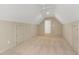Neutral carpeted bonus room with ceiling fan, dormer windows, and closet doors at 509 Edgemore Ave, Cary, NC 27519