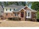 Charming brick-and-siding home featuring an arched doorway and well-manicured landscaping at 509 Edgemore Ave, Cary, NC 27519