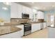 Charming kitchen with white cabinets, granite countertops, stainless steel appliances, and tile backsplash at 509 Edgemore Ave, Cary, NC 27519