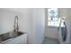 Laundry room featuring stainless steel utility sink, and washer/dryer with natural light at 509 Edgemore Ave, Cary, NC 27519