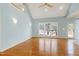 Bright living room with hardwood floors, vaulted ceiling, ceiling fan, and large windows overlooking backyard at 509 Edgemore Ave, Cary, NC 27519