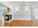 Cozy living room featuring hardwood floors, a fireplace, and elegant wall sconces at 509 Edgemore Ave, Cary, NC 27519