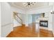 Spacious living room with hardwood floors, a modern chandelier, and a cozy fireplace at 509 Edgemore Ave, Cary, NC 27519