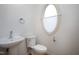 Powder room featuring pedestal sink, toilet, and a unique oval window at 509 Edgemore Ave, Cary, NC 27519