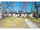 Charming one-story brick home with a walkway leading to the front door and mature trees at 510 Corrida Ave, Durham, NC 27704