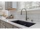 Close-up of a kitchen sink with stone countertops, modern faucet, subway tile backsplash, and gray cabinets at 5102 Highcroft Dr, Cary, NC 27519