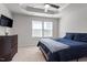 A calm bedroom with a ceiling fan and an adjacent dresser by a pair of sunlit windows at 515 Autumn Cure Ct, Fuquay Varina, NC 27526