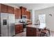 Modern kitchen with stainless steel appliances, wood cabinets, and a breakfast bar at 515 Autumn Cure Ct, Fuquay Varina, NC 27526