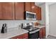 Close-up of the kitchen appliances: stainless steel oven, microwave, and granite countertops at 515 Autumn Cure Ct, Fuquay Varina, NC 27526