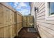 Side yard featuring a wooden fence, gravel bed, and outdoor shower, providing privacy and convenience at 517 Coleman St, Raleigh, NC 27610