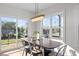 Inviting dining area with natural light, a modern light fixture, and a door to a balcony for indoor-outdoor enjoyment at 517 Coleman St, Raleigh, NC 27610