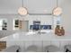Modern kitchen with white cabinets, a sleek island with bar seating, and blue backsplash offers style and functionality at 517 Coleman St, Raleigh, NC 27610