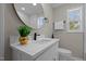 Modern bathroom with marble countertops, a gold-trimmed mirror, and updated fixtures at 518 W Chisholm St, Sanford, NC 27330