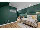Inviting bedroom features modern decor, wood floors, accent wall and comfortable furnishings at 518 W Chisholm St, Sanford, NC 27330