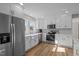 Bright kitchen with white cabinets, marble backsplash, stainless appliances, farmhouse sink, and wood-look floors at 518 W Chisholm St, Sanford, NC 27330