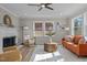 Bright living room with fireplace, ceiling fan, wood floors, and natural light from a double window at 518 W Chisholm St, Sanford, NC 27330