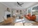 Bright living room featuring fireplace, modern ceiling fan, hardwood floors, and ample natural light at 518 W Chisholm St, Sanford, NC 27330