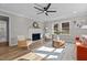 Bright living room with fireplace, ceiling fan, wood floors, and natural light from a double window at 518 W Chisholm St, Sanford, NC 27330